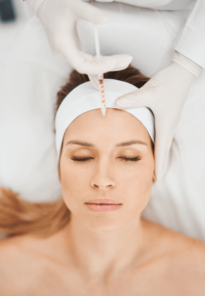 Woman receiving neurotoxin treatment in her forhead to help reduce signs of aging and achieve a refreshed youthful appearance