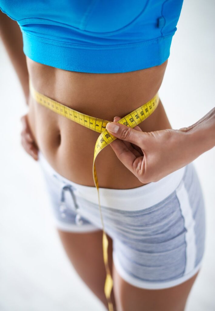 Woman measuring her weight after medical weight loss